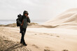 © Cavan Images - Smiling Woman hiking sand dunes in coastal Oregon