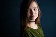 © Cavan Images - Portrait of a cute little 9 year old girl on dark background 