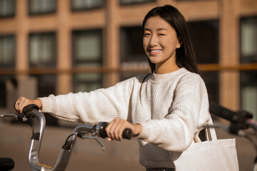 Asian girl with bike looking at camera