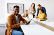 © BGStock72 - Young African American business man working with digital tablet in front of his coworkers at boardroom