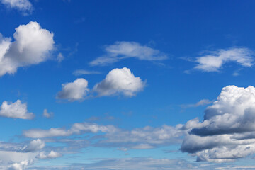  blue sky with white cumulus clouds of various sizes as a natural background