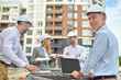 © zinkevych - Worker standing among his three coworkers on the construction site
