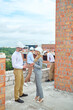 © zinkevych - Smiling female supervisor communicating with a foreman outdoors
