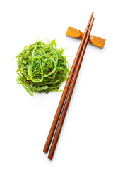 Wall Mural - Green wakame. Seaweed salad and chopsticks isolated on white background.