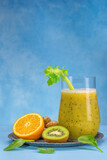 Fototapeta Kuchnia - Glass of green spinach, orange, ginger and kiwi healthy smoothies.