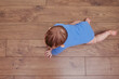 © Андрей Журавлев - Happy baby toddler crawls on a wooden laminate. Funny child on the parquet in the home living room, aged 6-11 months