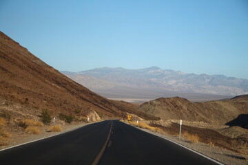 The black asphalt road with the mountains of the left and on distance