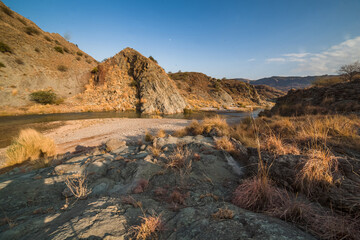 Sticker - A landscae view of a river surrounded by forests and rocks