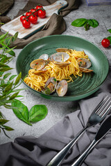 Wall Mural - Traditional Italian seafood pasta with shellfish Spaghetti alle Vongole in a plate on a gray stone table. Restaurant Menu