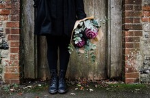 Womens Boots By An Old English Door With A Bouquet Of Flowers