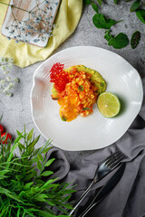 Sticker - Mango and salmon salad with gravy and mashed avocado and lime in a plate on a gray stone table. Restaurant Menu