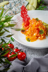 Sticker - Mango and salmon salad with gravy and mashed avocado and lime in a plate on a gray stone table. Restaurant Menu