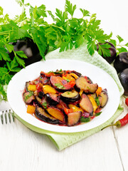 Poster - Eggplant with plums in plate on white board