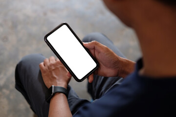 Wall Mural - young man holding mockup smart phone with empty screen. close up..