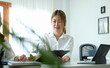 © wattana - Young asian business woman analysing financial reports with her colleague at comfortable workplace.