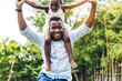 © Art_Photo - Portrait of enjoy happy love black family african american father carrying daughter little african girl child smiling and having fun moments good time in summer park at home