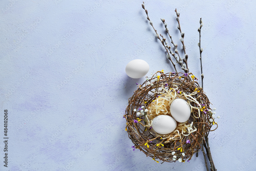 Nest with beautiful Easter eggs and willow branches on blue background ...
