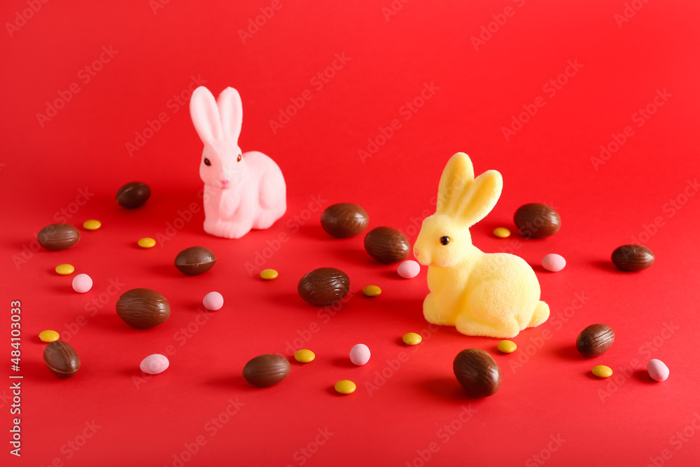 Chocolate Easter eggs and bunnies on red background