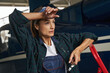 © Svitlana - Beautiful woman airframe mechanic wearing overall standing in aviation garage
