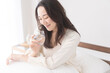 © lielos - 寝室で水を飲む女性