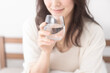 © lielos - 寝室のベッドで水を飲む女性