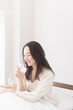 © lielos - ベッドで水を飲む女性