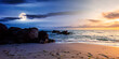 © Pellinni - day and night time change concept above huge stones on the sandy beach at twilight. wonderful velvet season vacation. clouds on the blue sky with sun and moon above horizon. waves washing the shore