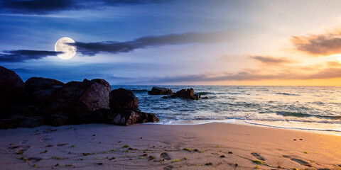 Wall Mural - day and night time change concept above huge stones on the sandy beach at twilight. wonderful velvet