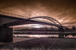 ogromny most nad rzeką i dramatyczne wieczorne niebo z zachodzącym słońcem