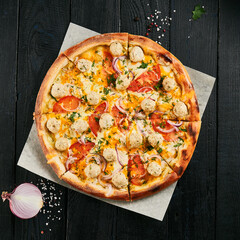 Sticker - American pizza with chicken meatballs on dark wood background. Italian dish - cheese pizza with  meatballs on parchment. Junk food on wooden table. Homemade pizza in rustic style.