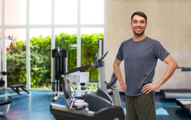 Poster - fitness, sport and healthy lifestyle concept - smiling man in sports clothes over gym background