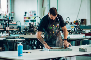 Wall Mural - Male worker preparing screen printing film in a workshop