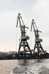  Green port cranes, close-up vertical photo