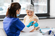 © Syda Productions - medicine, health and vaccination concept - doctor or nurse applying medical patch to vaccinated senior woman at hospital