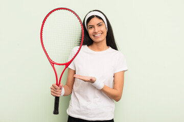 Wall Mural - young pretty hispanic woman smiling cheerfully, feeling happy and showing a concept. tennis concept