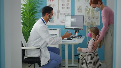 Wall Mural - little girl with her mother at doctor's office on consultation, coronavirus concept.