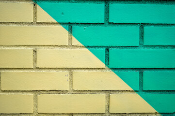 A Two Toned Painted Brick Wall In Yellow And Green