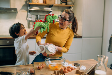 Wall Mural - mother and her son preparing food in kitchen