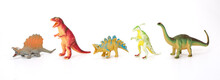 Various Dinosaurs From Prehistoric Times In A Row On White Background.