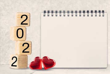 Wall Mural - 2022 cubes with red heart shape and empty notebook on table, Love and Happy Valentine day concept