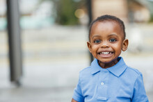 A Cute One Year Old Toddler Almost Preschool Age African-American Boy With Big Eyes Smiling And Looking Away With Copy Space
