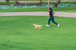 © Quang - Asian woman jogging with her golden dog at the park