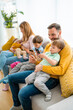 © NDABCREATIVITY - Parents with children playing games, using mobile apps on phone at home