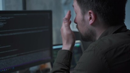 Tired exhausted freelance programmer, rubbing his eyes and head, suffering from eye strain while sitting at desk. Specialist, remote worker, has dry eye syndrome, fatigue after long work at computer.