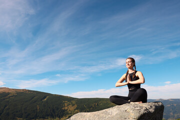 Wall Mural - Young woman practicing outdoor yoga in mountains, space for text. Fitness lifestyle