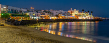 View Of Restaurants And Shops Overlooking Playa Blanca Beach At Dusk, Playa Blanca, Lanzarote, Canary Islands