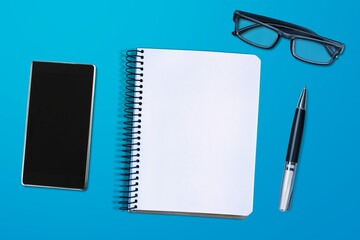 Canvas Print - Desk with pen, glasses, smartphone and notebook