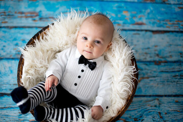 Canvas Print - Little baby boy with knitted ladybug hat and pants in a basket