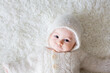 © Tomsickova - Close portrait of a little baby boy in white knitted onesie and a hat