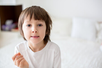 Little smiling child boy hand pointing his first baby milk tooth fall out